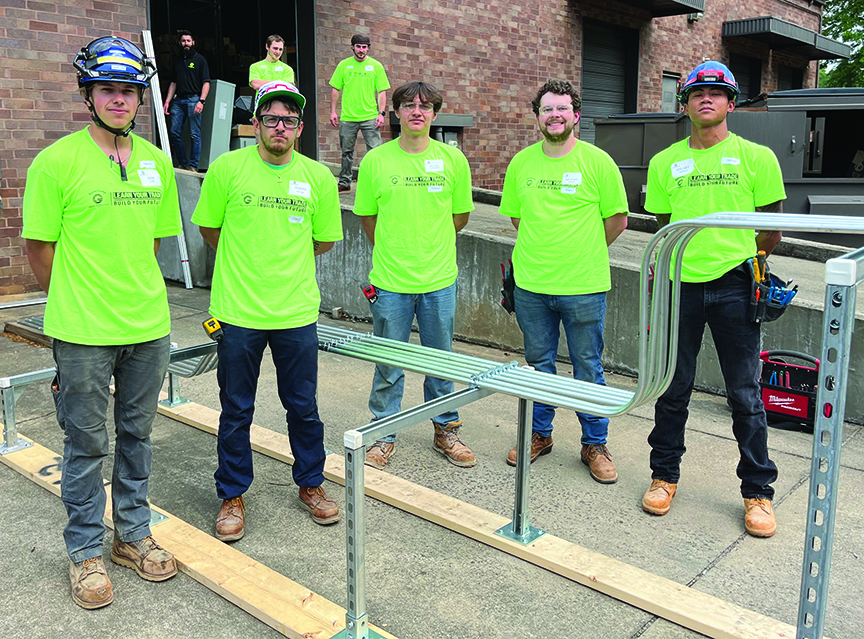 A group of construction workers in hard hats and safety vests.